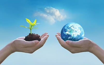 Hands holding a sprout and the Earth